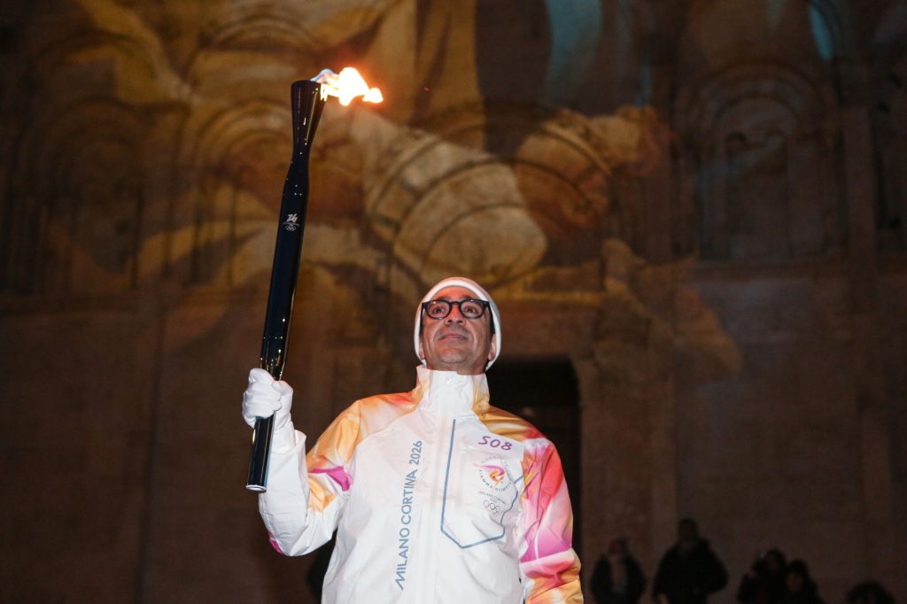 Un tedoforo davanti il Duomo con la Torcia Olimpica a Termoli